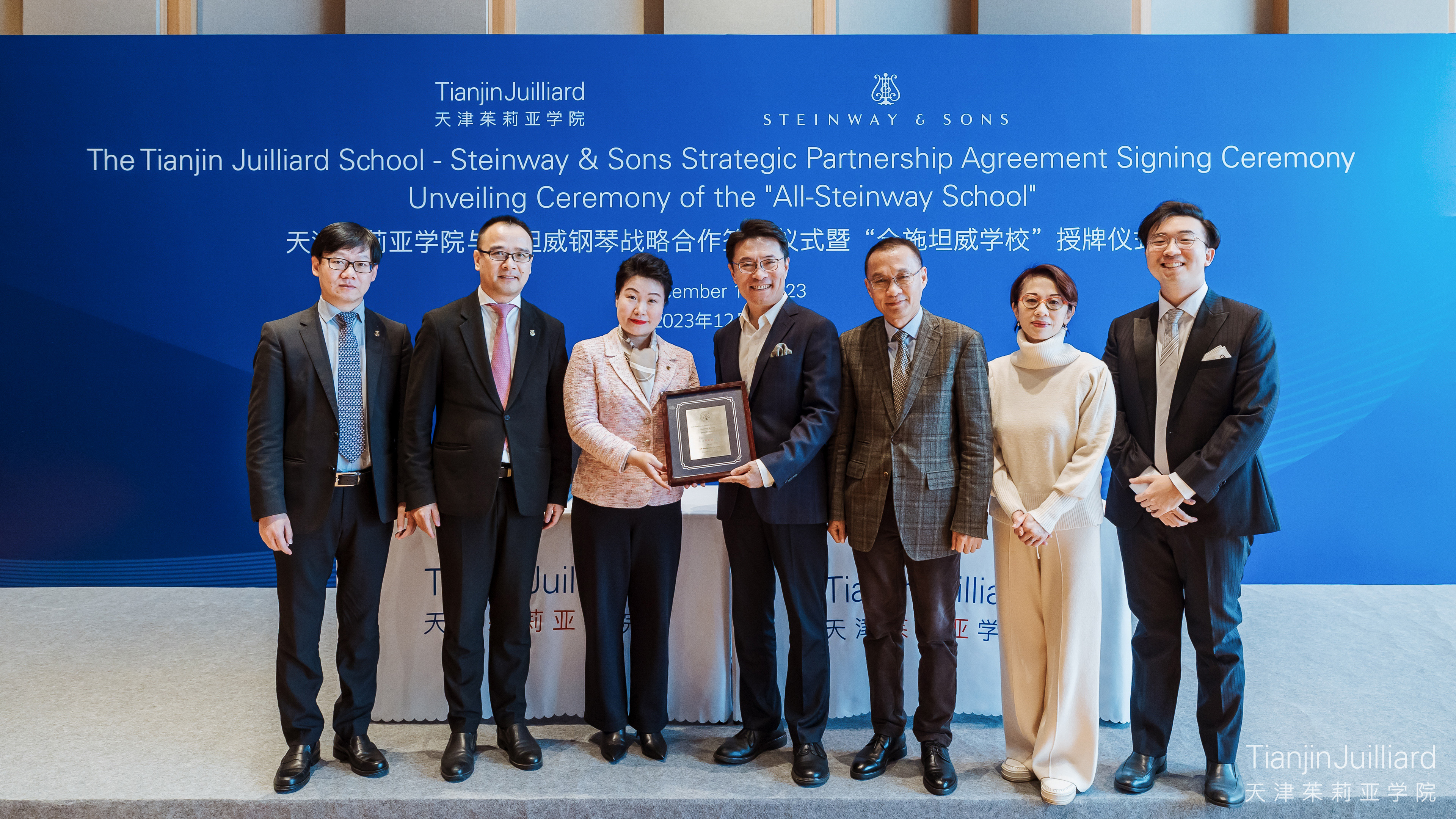 Representatives from Tianjin Juilliard and Steinway and Sons pose with All-Steinway School plaque
