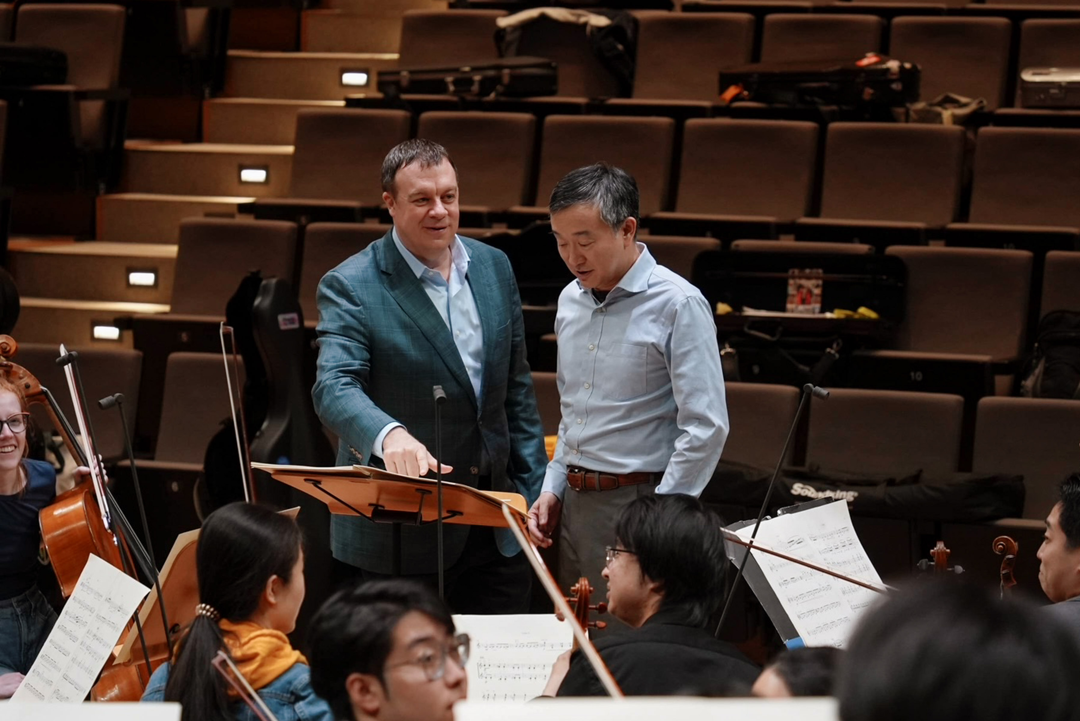 Dr. Wayne Oquin works with students during an orchestra rehearsal.
